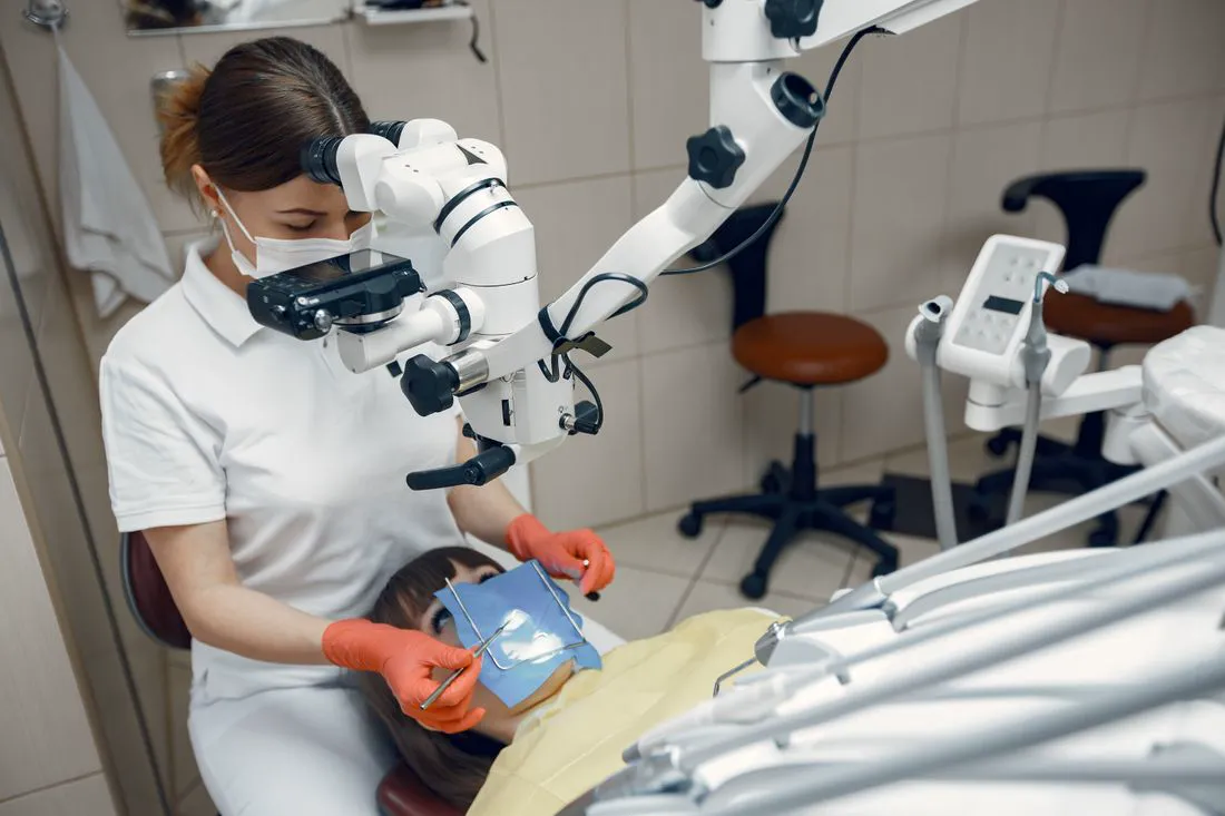 A dentist working with a dental microscope