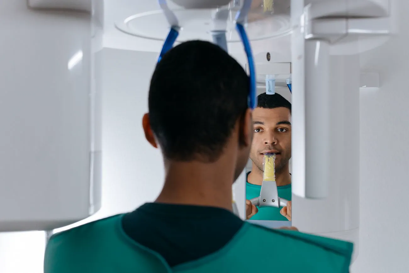 A patient standing in a panoramic dental scanner